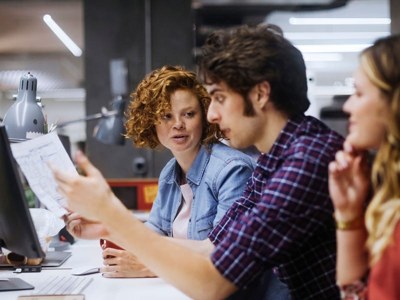 Group of students sitting at a table talking about their language course