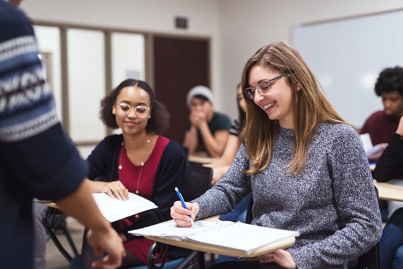 Students smiling and writing during their language class