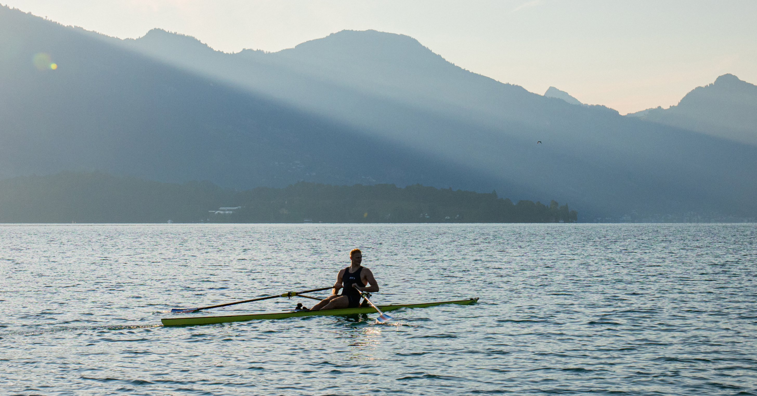 Professional rower demonstrating rowing technique on open water