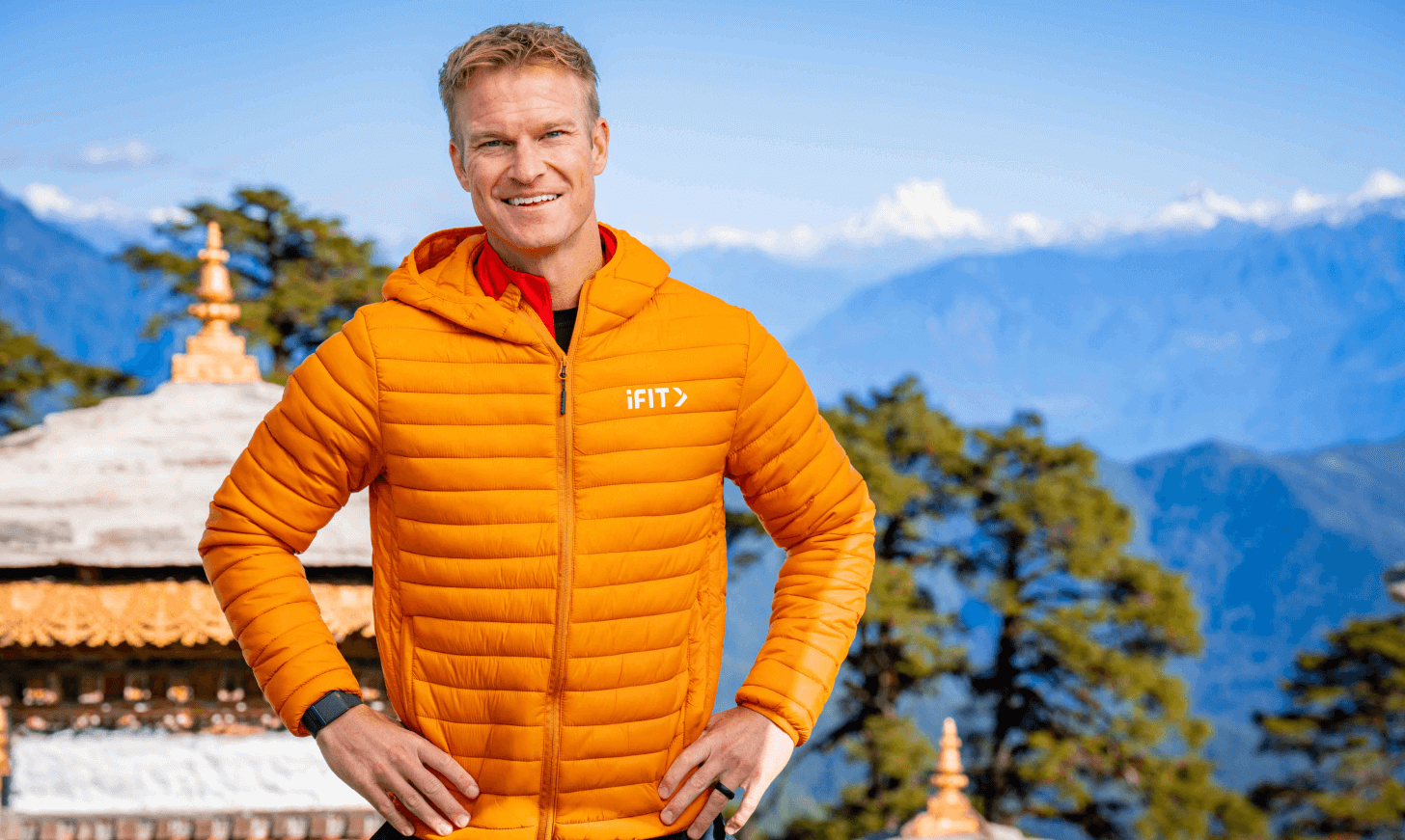 iFIT Trainer John Peel stands in front of Bhutanese architecture.