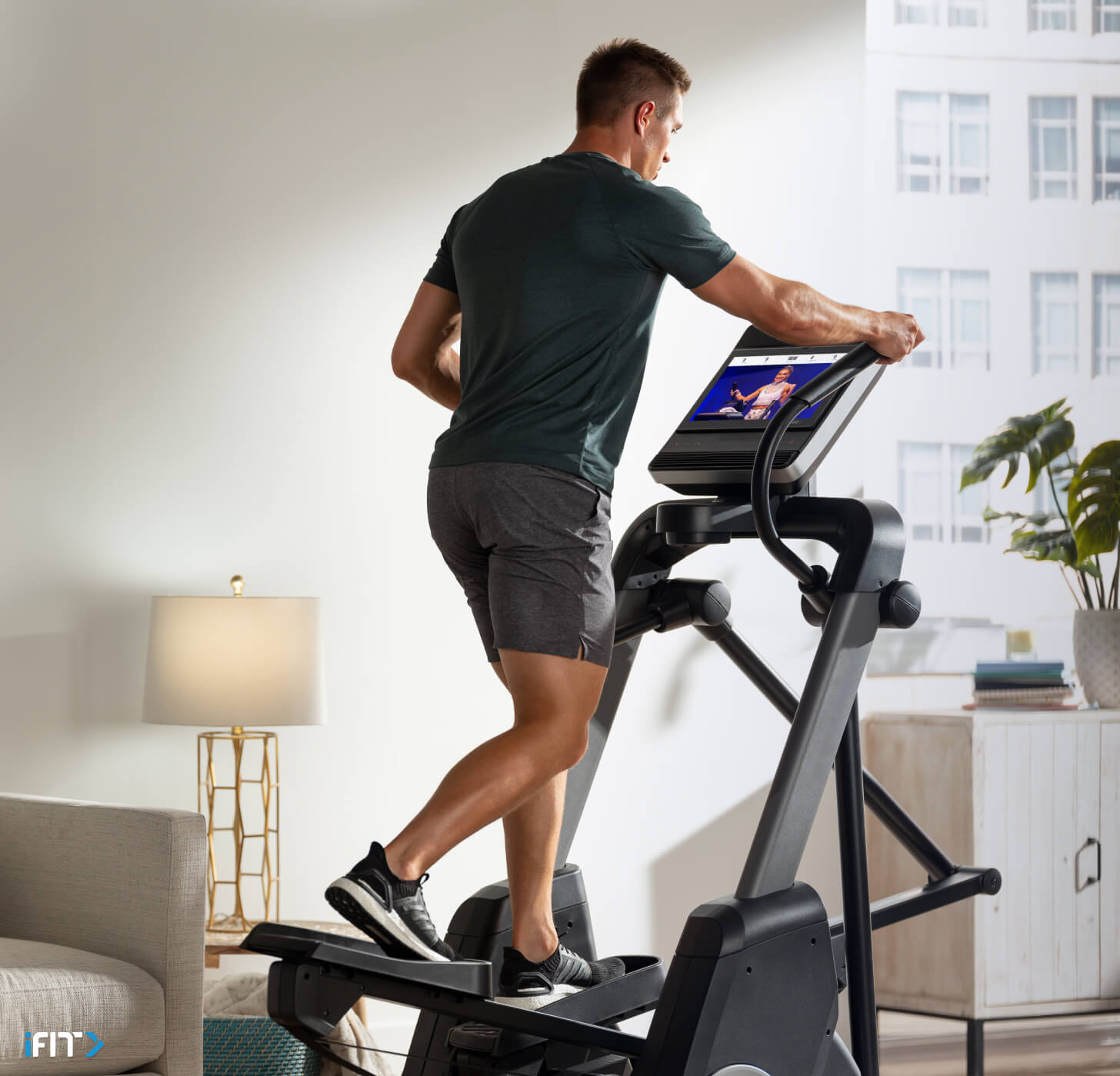 Man does an iFIT elliptical class Man works out with an iFIT elliptical class