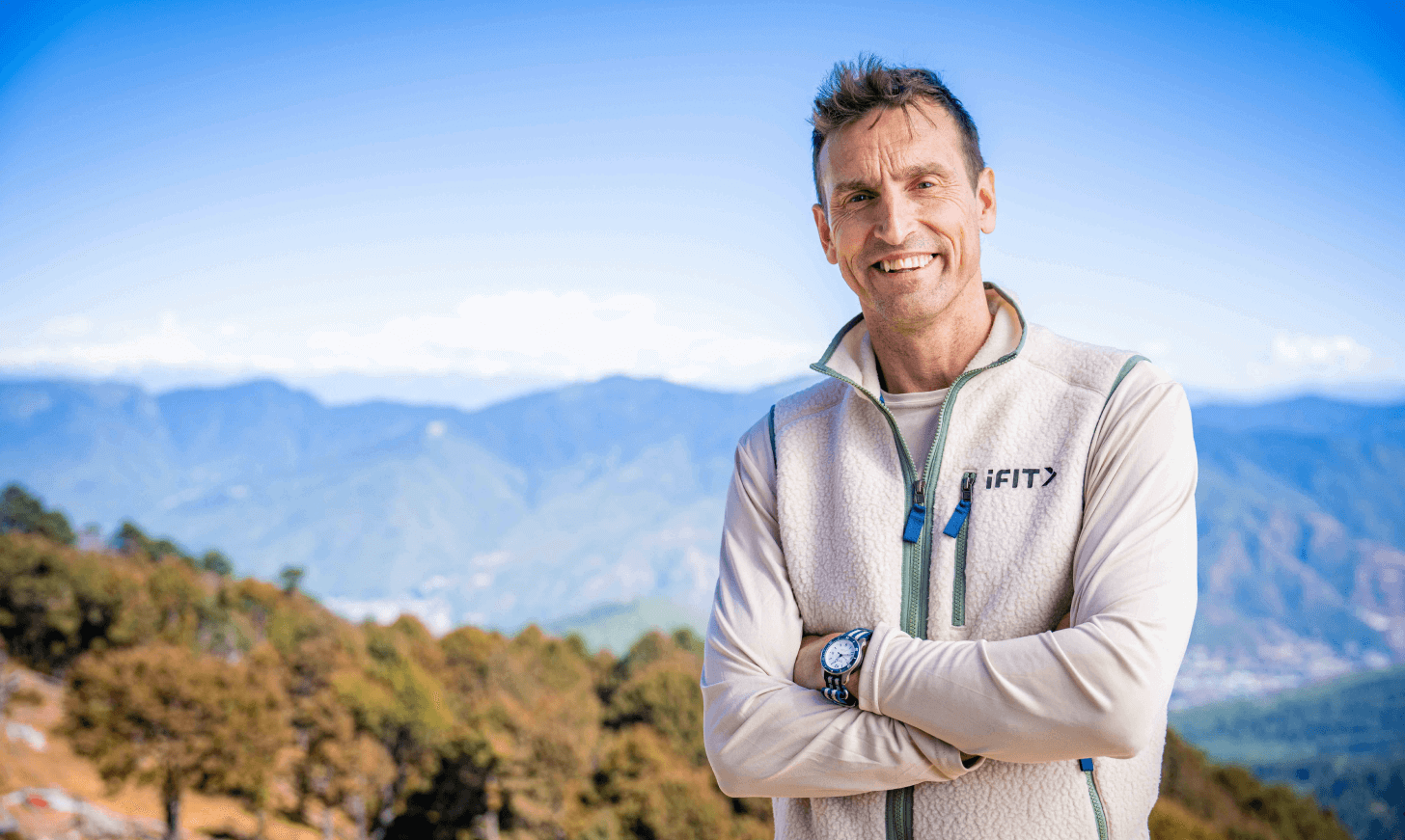 iFIT Guide Kenton Cool stands in front of the Himalayan Mountains in Bhutan.
