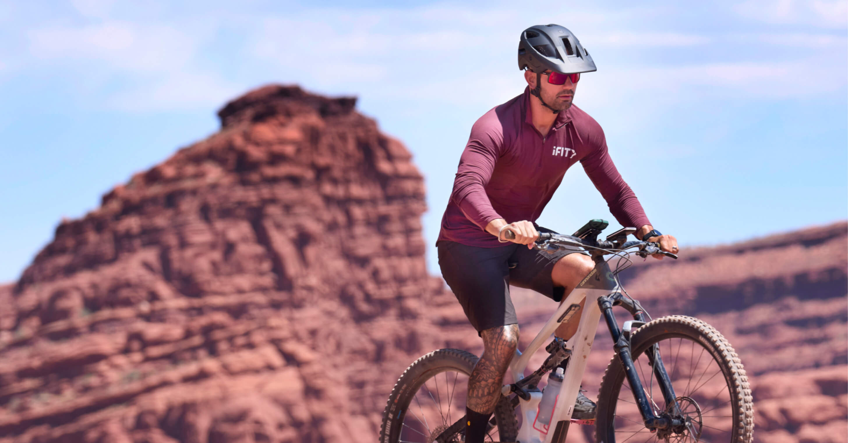 Trainer Paulo Barreto rides red rock trails on the iFIT app's Canyonlands National Park cycling Challenge.