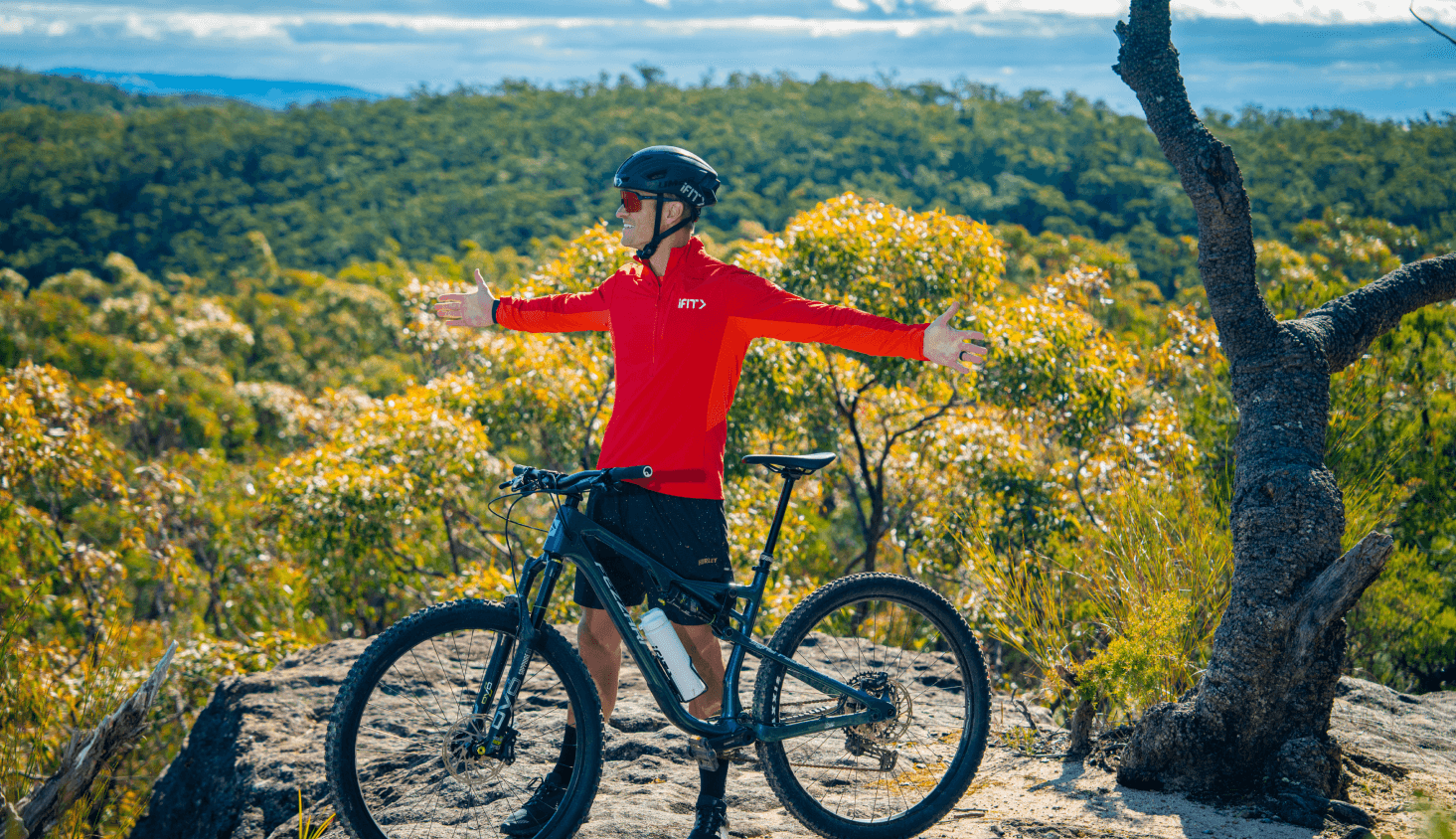 iFIT Trainer John Peels stands with this bike, while overlooking the Australian bush.