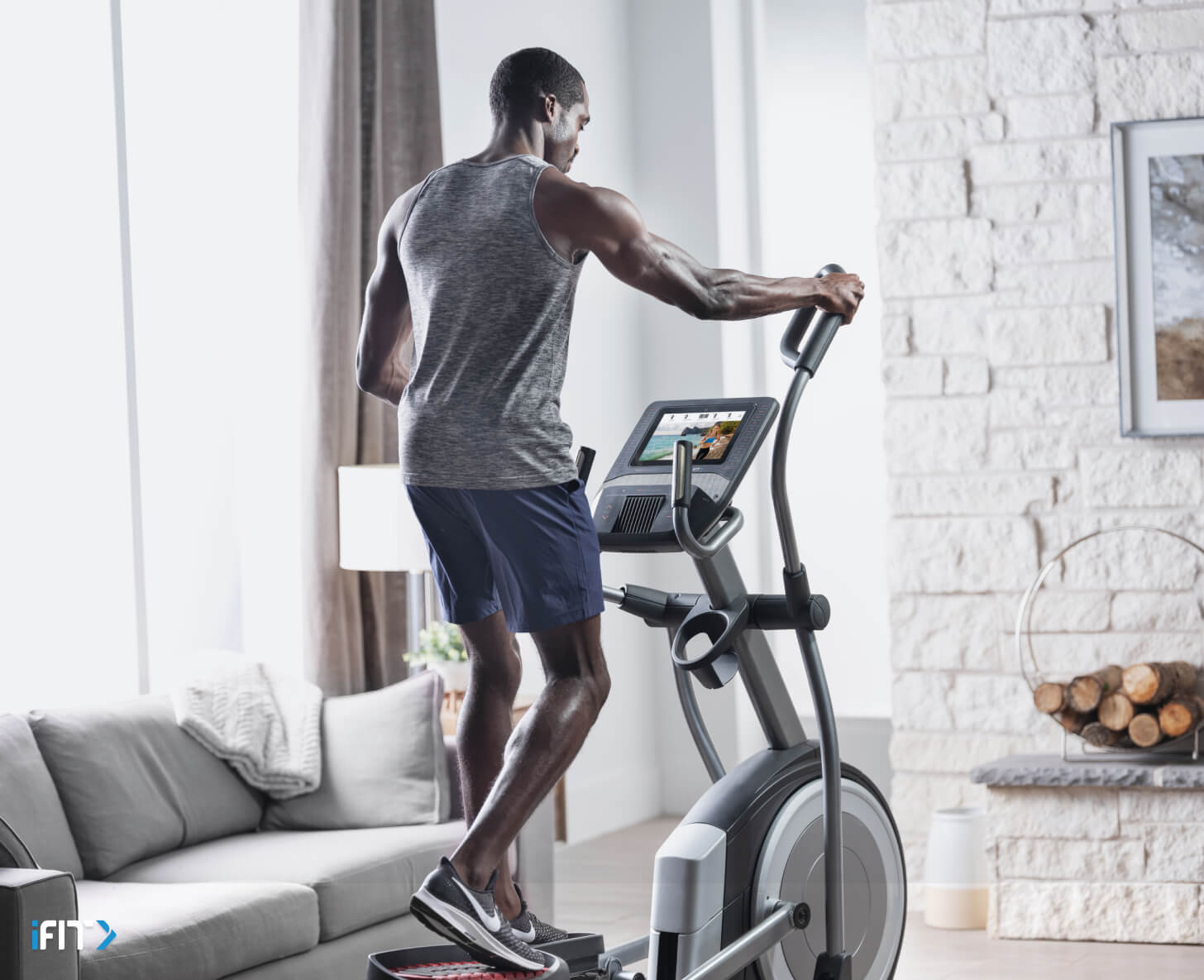 Man works out using iFIT elliptical exercises Man works out with iFIT elliptical exercises