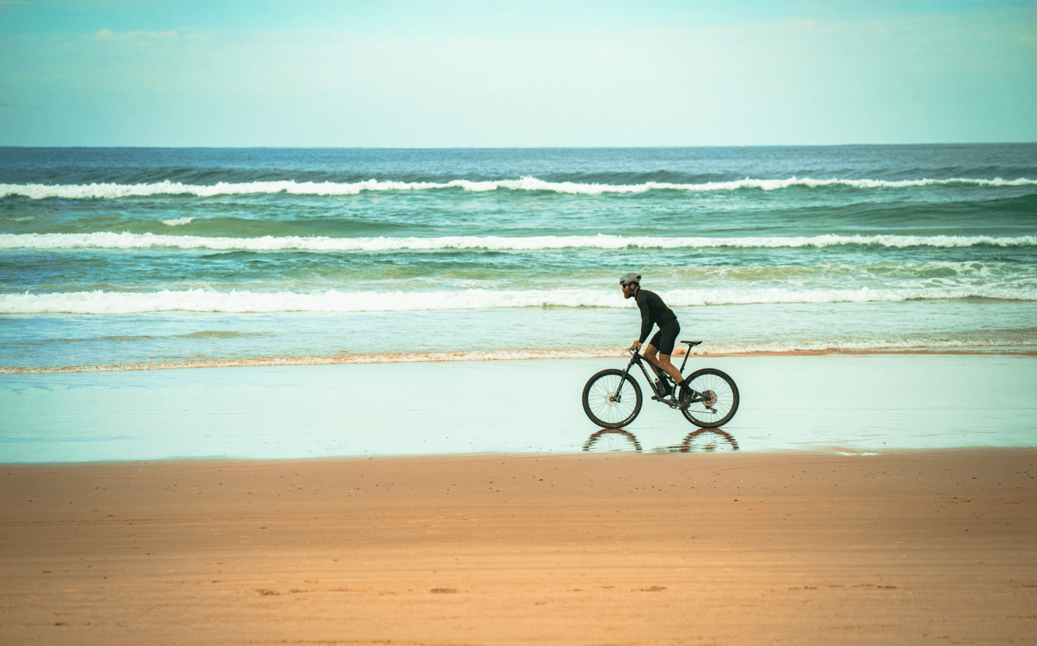 Tommy Rivs rides his bike along the beach in Queensland, Australia.
