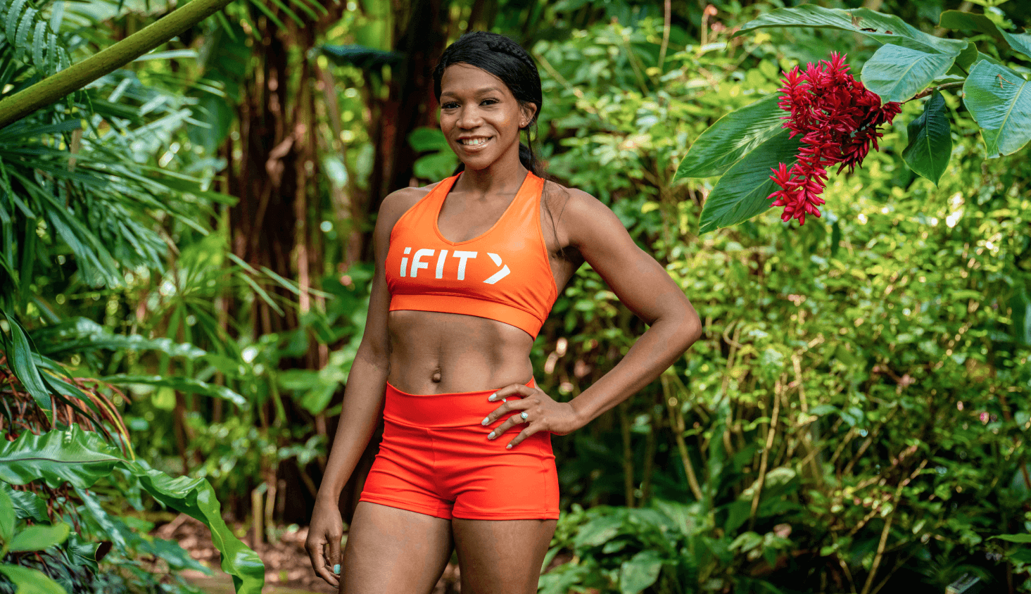 iFIT Trainer Shannon Cooper stands among green foliage in Australia.