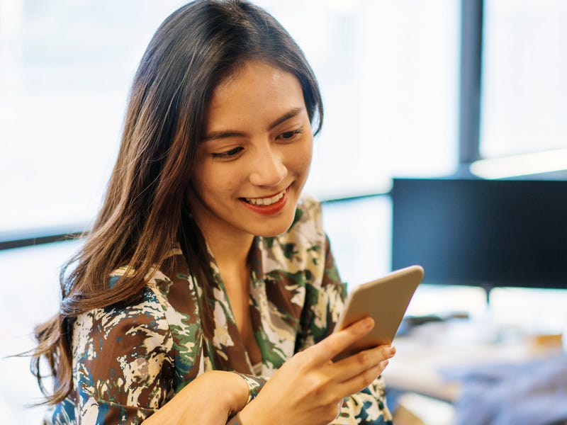 Eine Frau schaut auf ihr Smartphone.