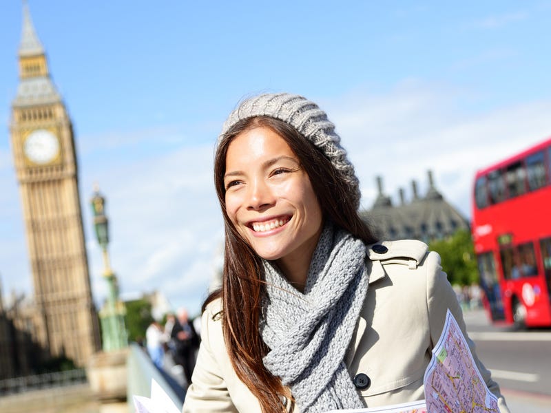 Frau steht in London auf einer Brücke vor dem Big Ben