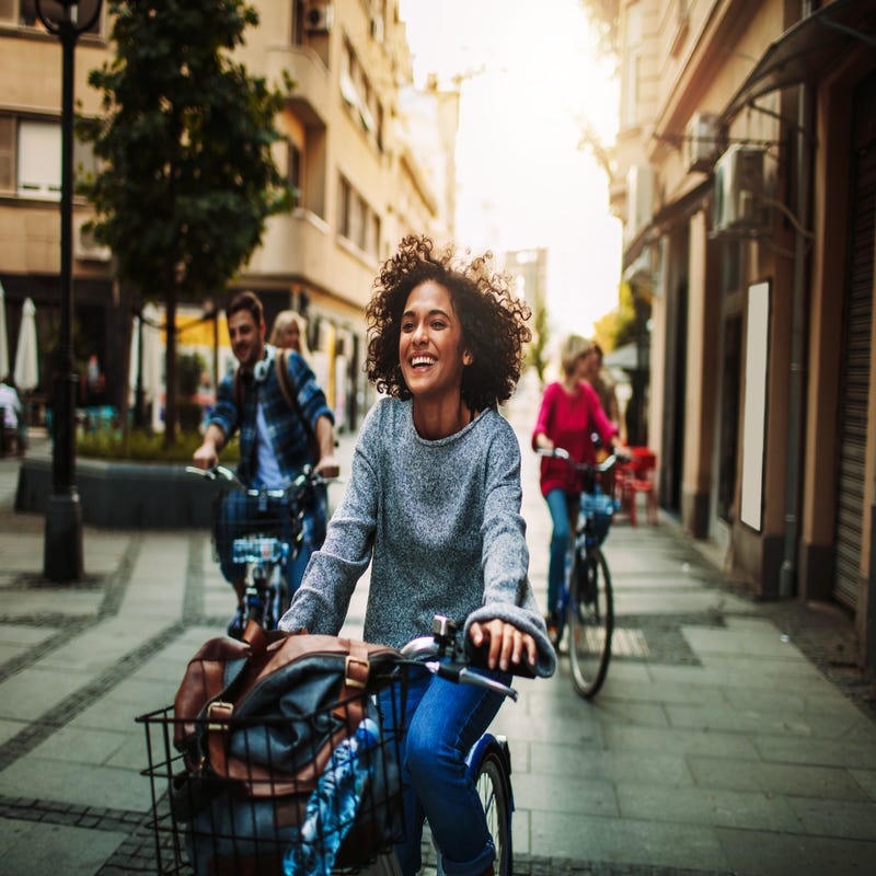 Eine Frau fährt mit dem Fahrrad durch eine Straße