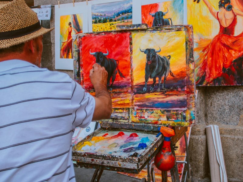 Ein Straßenmaler in Spanien mal Bilder von Stieren und einer Flamenco Tänzerin.