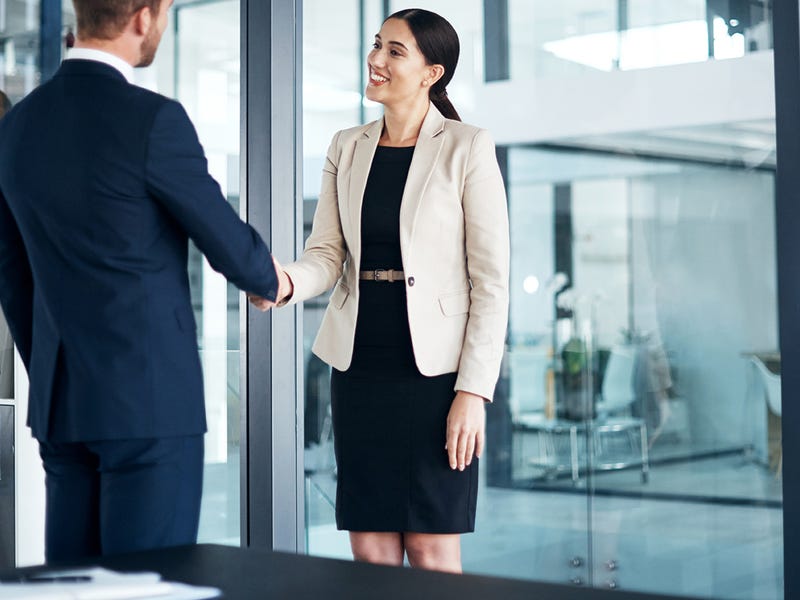 Frau und Mann reichen sich die Hand.