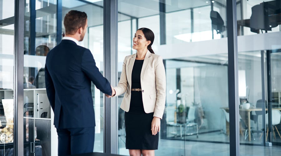 Frau und Mann reichen sich die Hand.