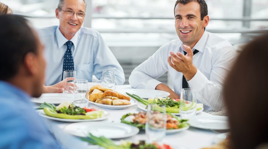 Mehrere Männer sitzen beim Business Lunch zusammen