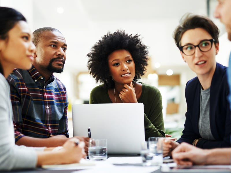 Fünf Personen sitzen zusammen und unterhalten sich