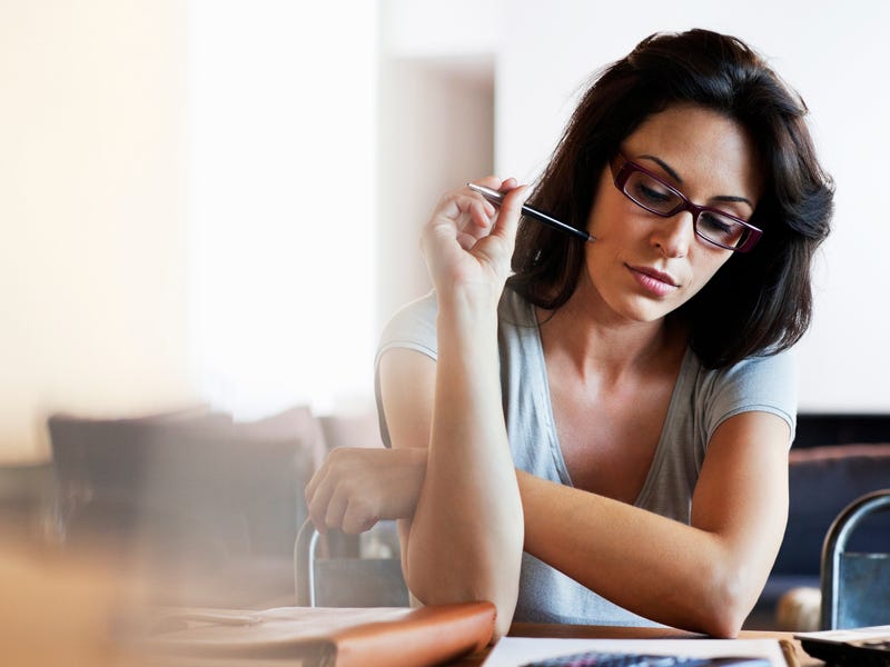 Eien Frau sitzt an ihrem Laptop und schreibt eine Liste.