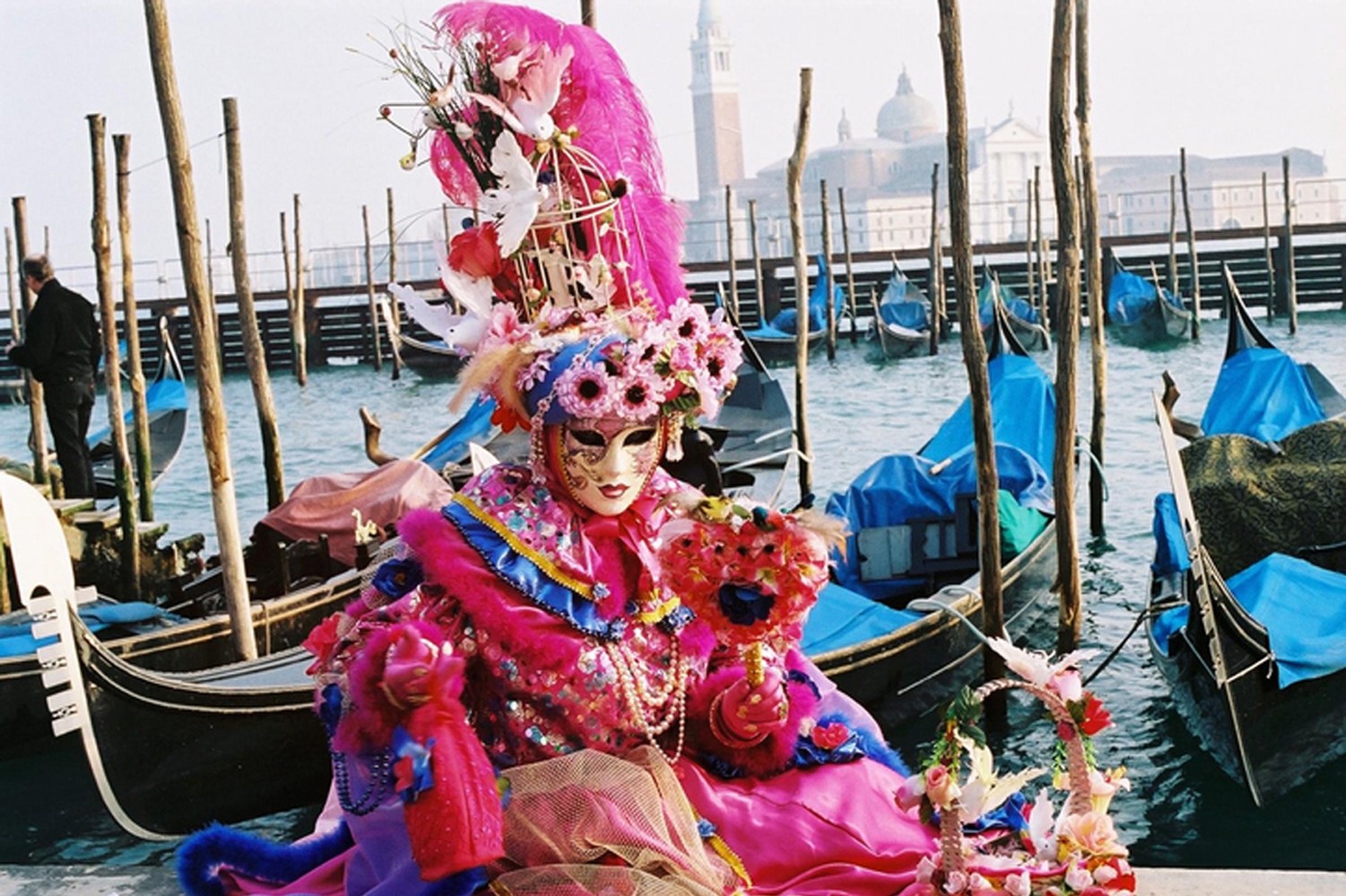 Eine verkleidete Person sitzt am Wasser.