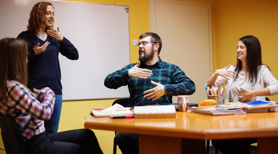 Mehrere Menschen führen spielerisch ein Meeting durch