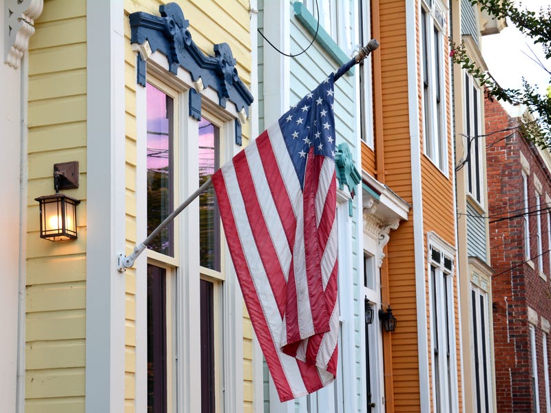 An American flag hanging on a house.
