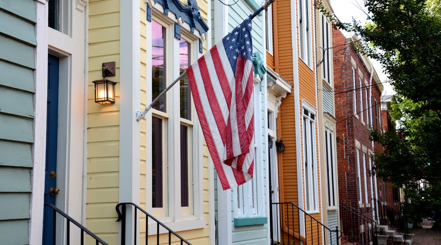 An American flag hanging on a house.