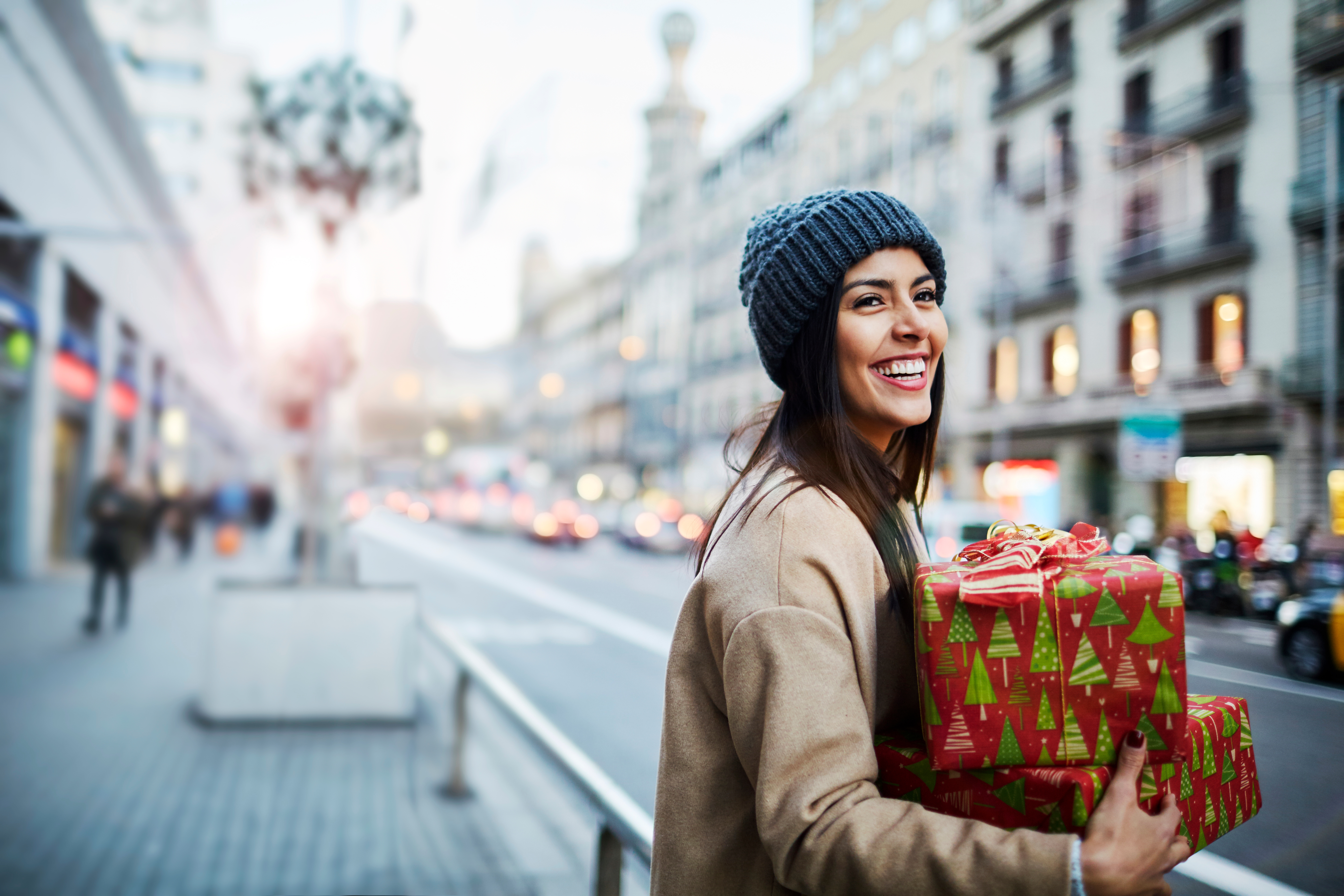 Eine Frau läuft mit einem Geschenk über die Straße