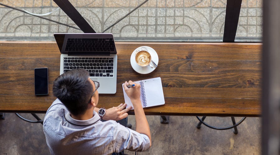 Mann sitzt am Schreibtisch und lernt online mit Berlitz am Laptop.