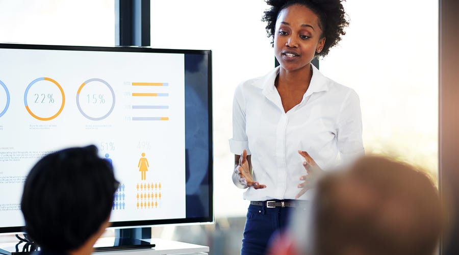 Frau hält Präsentation vor Kollegen.