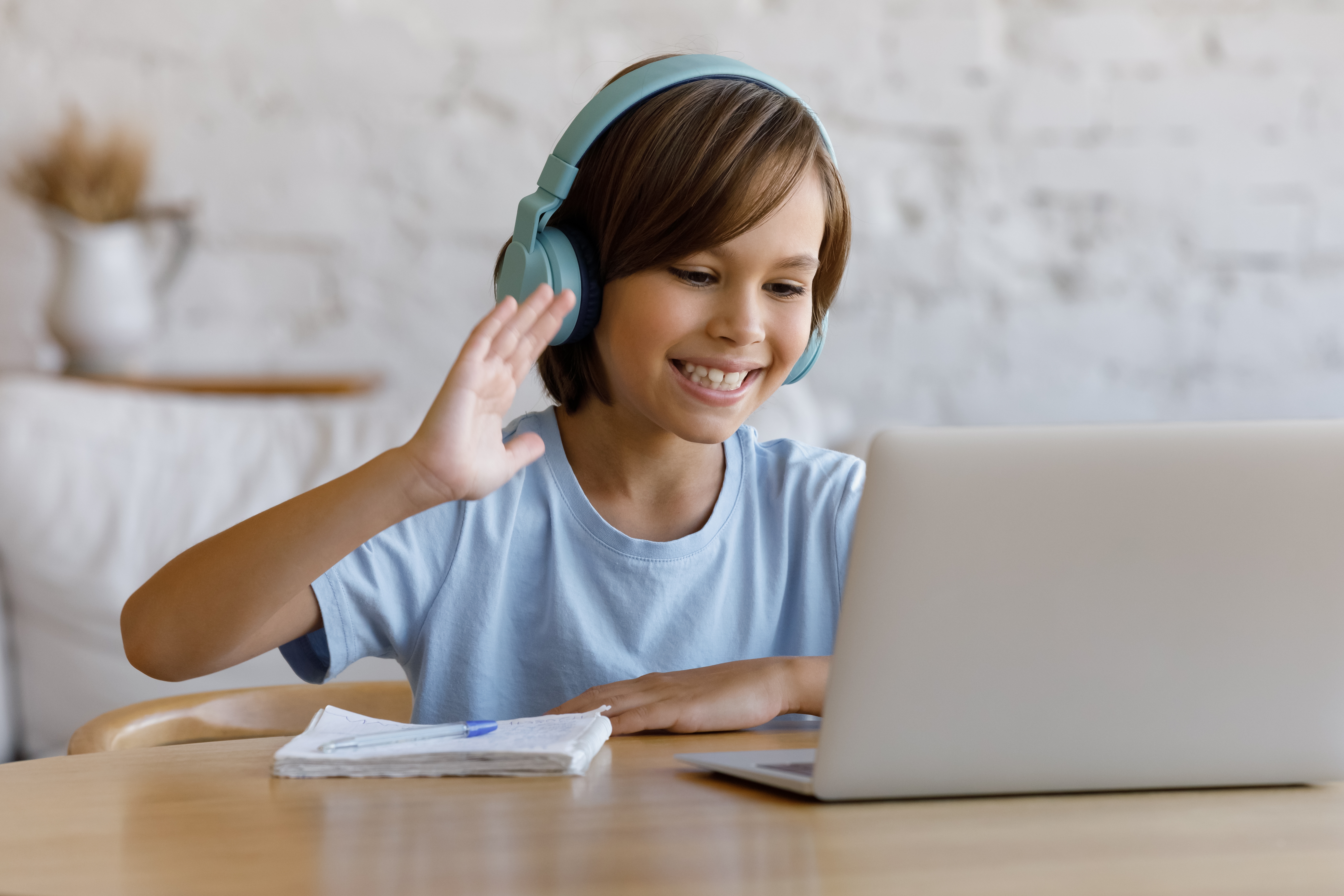 Ein Junge sitzt vor seinem Laptop und nimmt an einem Online Sprachkurs teil.