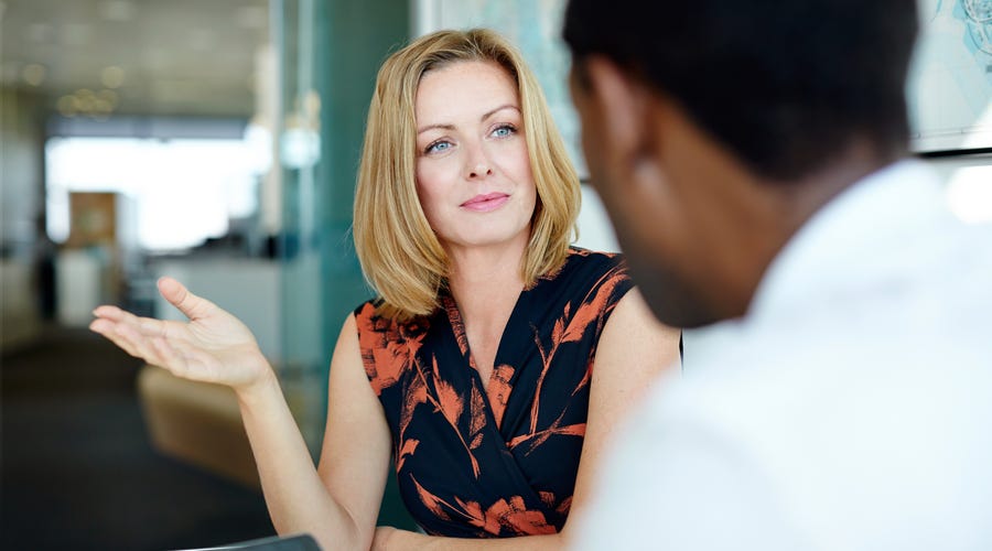 Frau sitzt an einem Tisch und unterhält sich