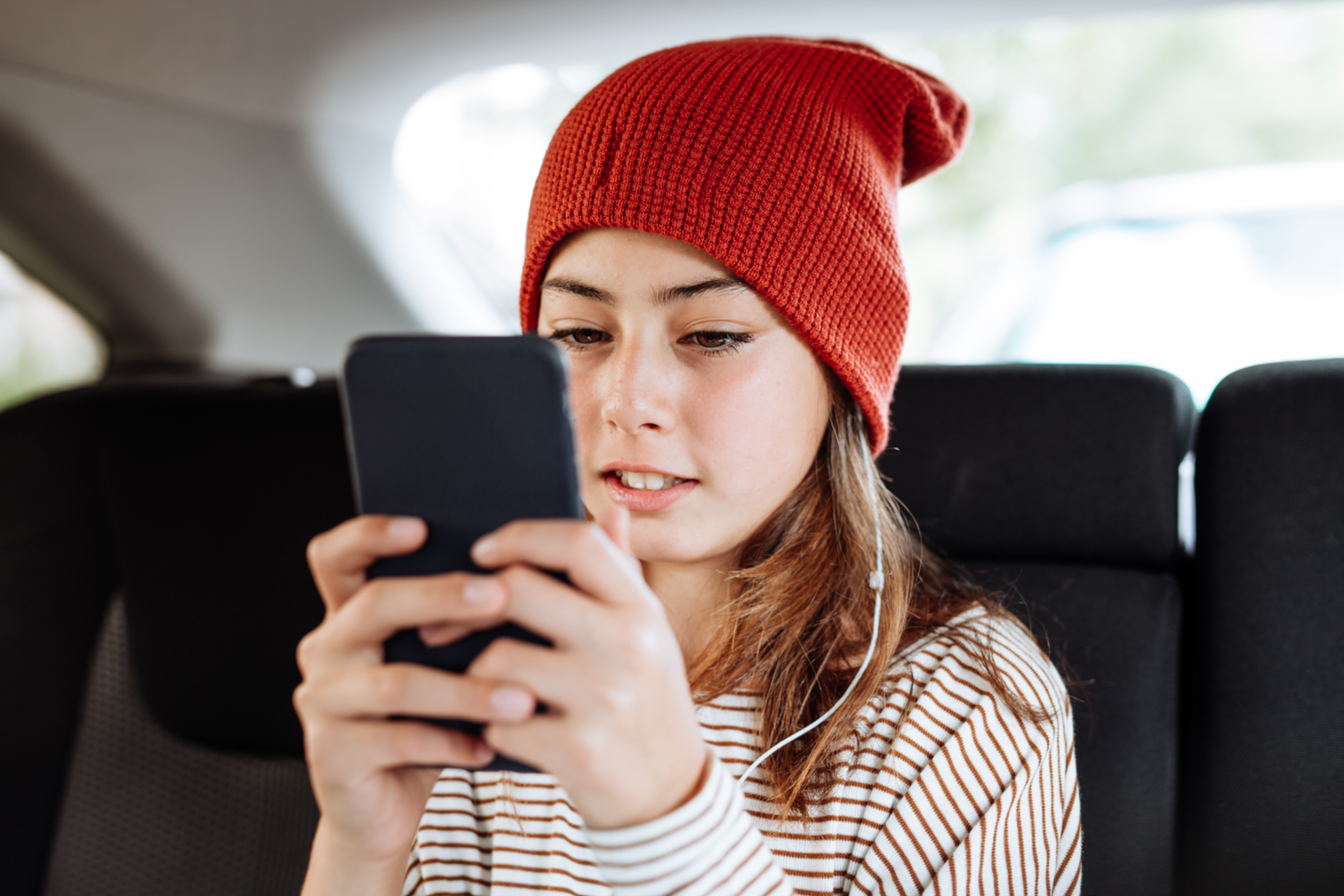 Mädchen tippt Nachricht in Smartphone