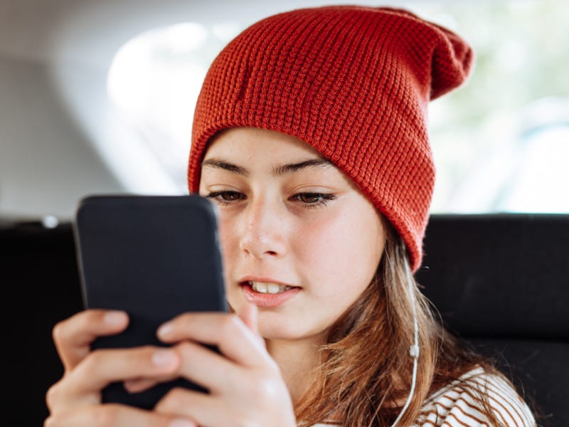 Mädchen tippt Nachricht in Smartphone