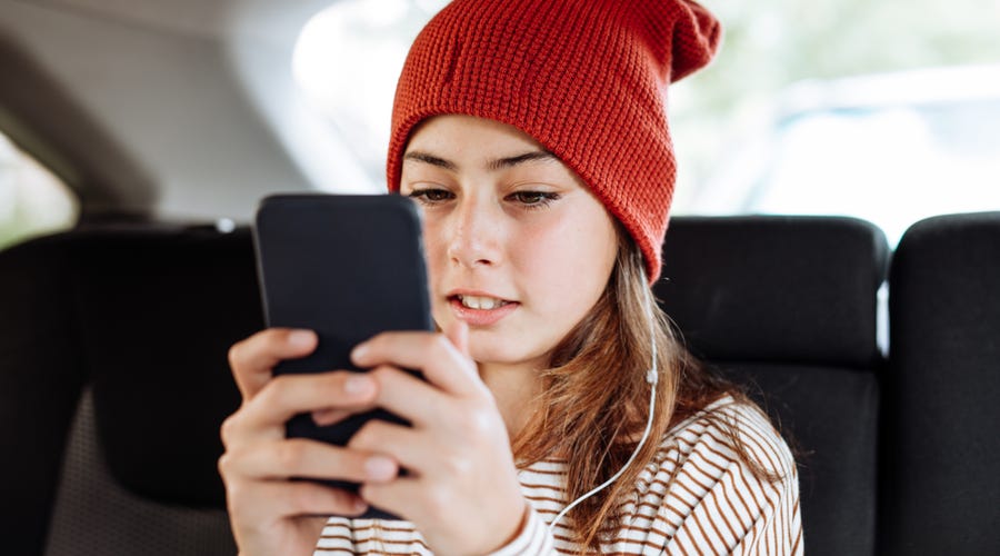 Mädchen tippt Nachricht in Smartphone
