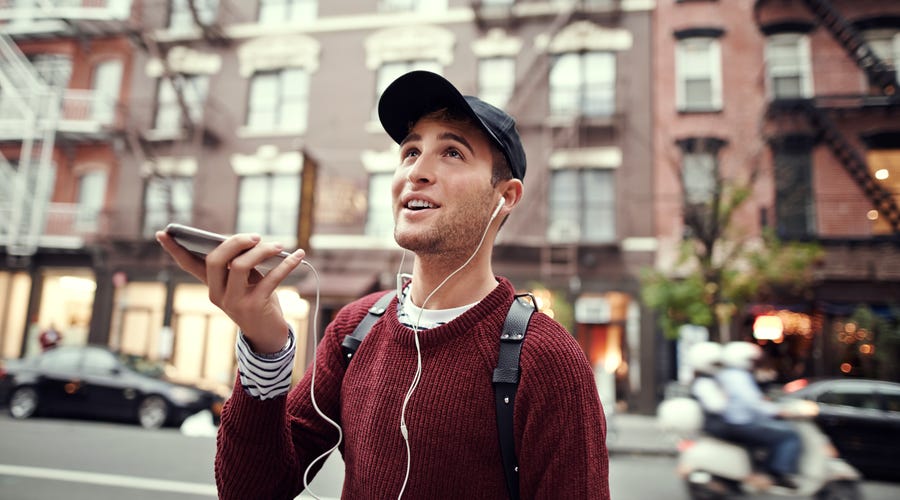 Mann hört mit Smartphone Musik und lernt dabei Sprachen