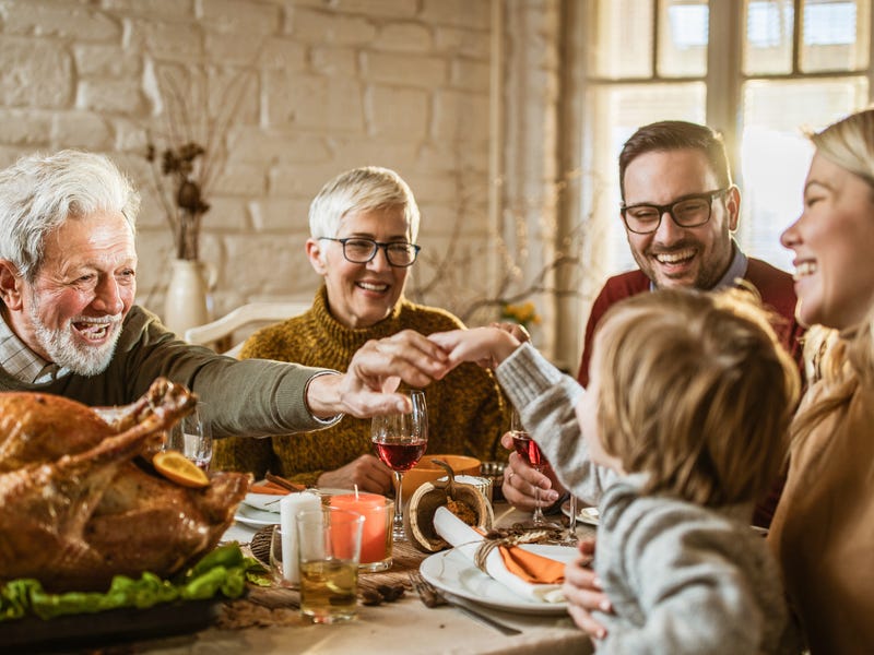 Eine Familie sitzt zusammen am Esstisch und feiert.