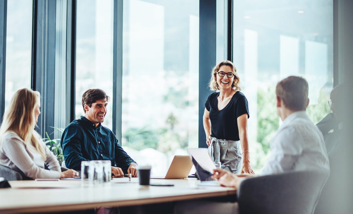 Eine Gruppe von Kollegen lacht während eines Sprachkurses für Unternehmen