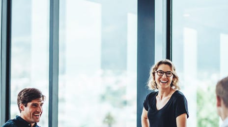 Eine Gruppe von Kollegen lacht während eines Sprachkurses für Unternehmen