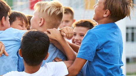 Mehrere Jungs sind in einem Sprachcamp unterwegs und haben Spaß beim Sport.