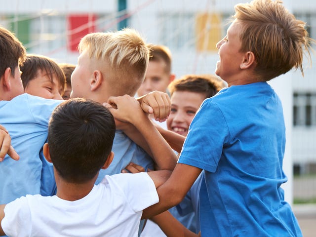 Mehrere Jungs sind in einem Sprachcamp unterwegs und haben Spaß beim Sport.
