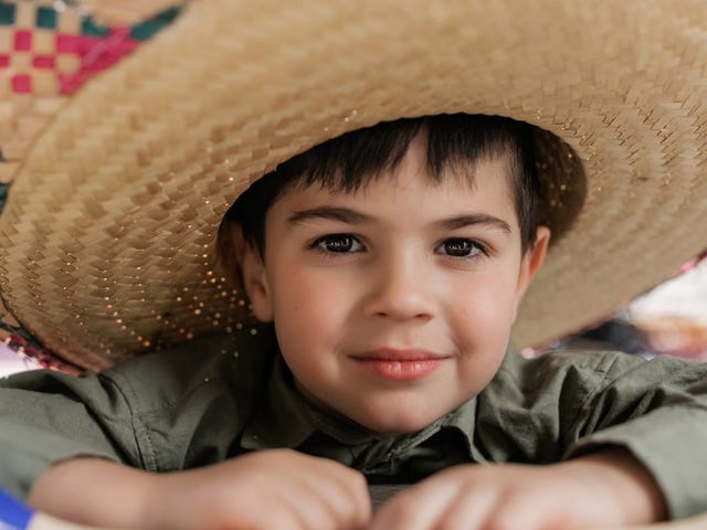 Ein Kind mit einem Stroh-Sombrero schaut in die Kamera. 