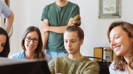 Mehrere Personen sitzen im Büro zusammen und besprechen eine Weiterbildung.