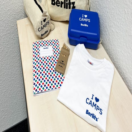 Das Berlitz Sprachcamps Welcome Paket mit Jutebeutel, Brotdose, Heftchen, Buntstiften, T-Shirt und Federmäppchen.