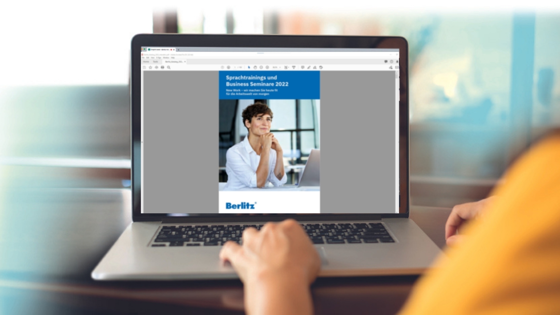 Eine Person blättert am Laptop durch den digitalen Berlitz Katalog.