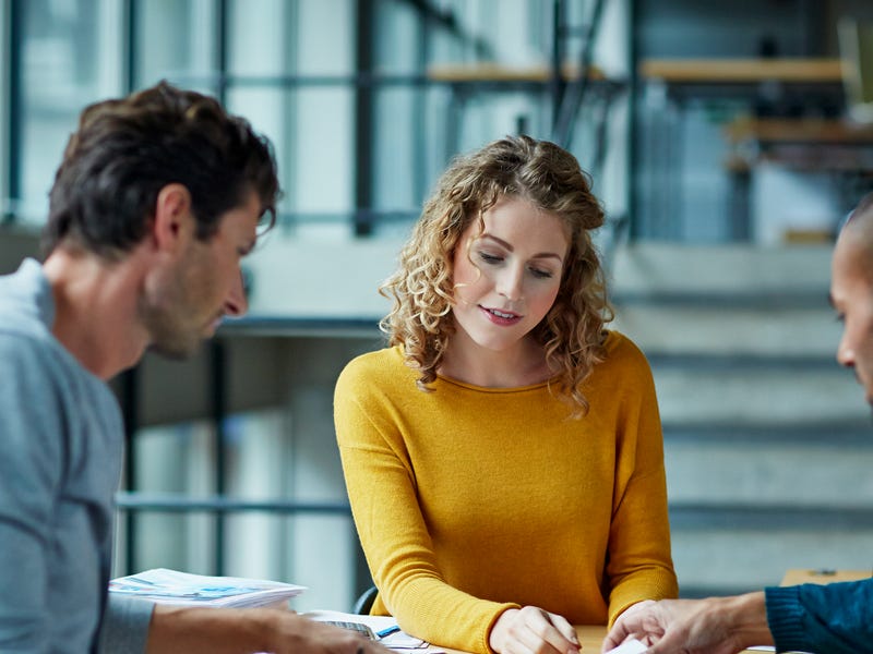 Mehrere Personen sitzen an einem Tisch und besprechen ein Projekt.