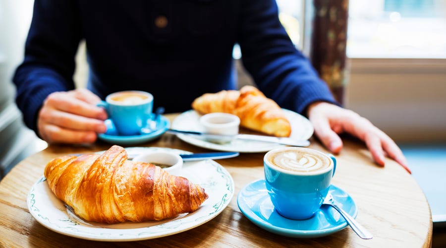 Croissants und Kaffee stehen auf einem Tisch bereit