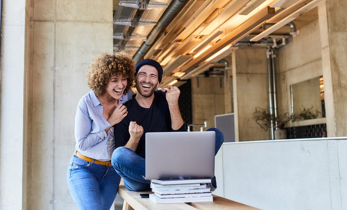 Ein Paar lacht beim Sprachenlernen im Blended-Learning-Format.