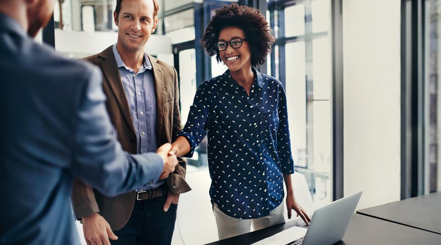 Frau schüttelt Hand nach Vertragsabschluss.