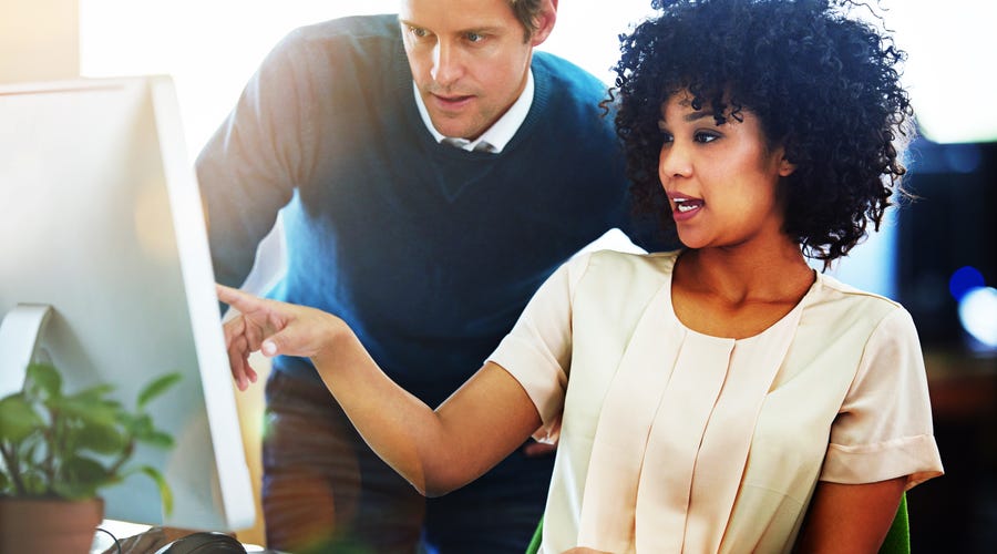 Frau und Mann unterhalten sich am Computer.