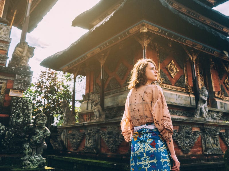 Junge Frau steht vor Tempelgebäude