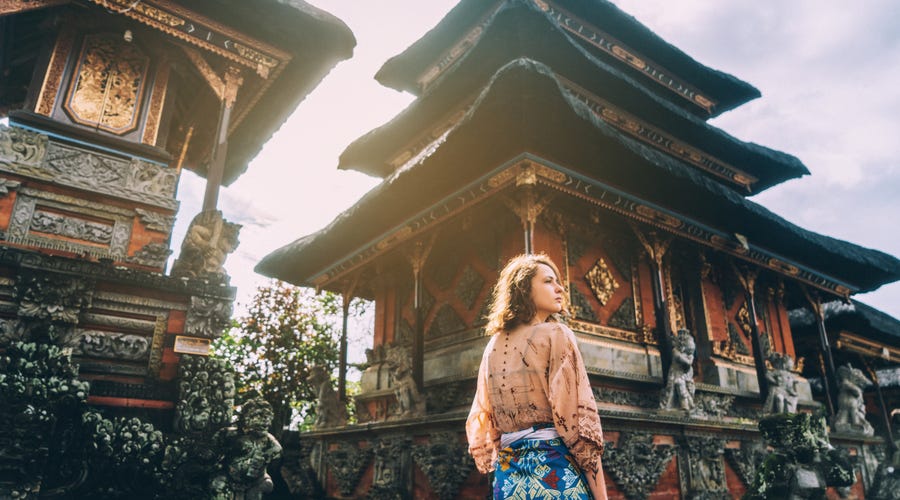 Junge Frau steht vor Tempelgebäude
