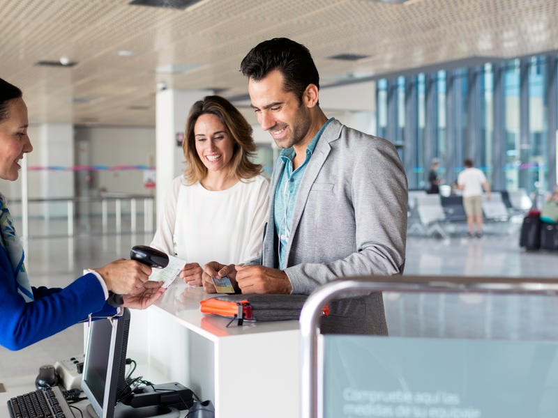 Ein Pärchen steht am Flughafen und checkt ein